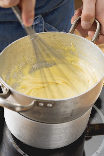 Hollandaise sauce being beaten in a bain marie