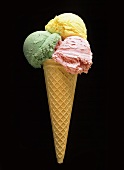 Pistachio, vanilla and strawberry ice cream in a cornet