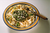 Ribbon Pasta with Spinach Pesto and Sunflower Seeds on Plate