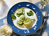 Spinatravioli mit Sahnesauce & Parmesan auf Teller
