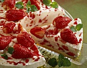 Strawberry cream gateau with pistachio border on glass plate