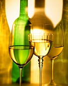 Various glasses of white wine and wine bottle
