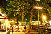 Abendliches Strassencafe an einer Metrostation in Paris