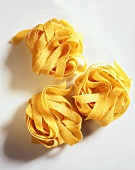 Three nests of fresh egg ribbon pasta (pappardelle)