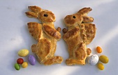 Two Easter bunnies made from dough with sugar eggs