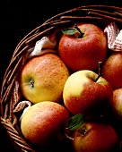 Frische Äpfel in einem braunen Weidenkorb