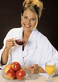 Smiling blond woman with a glass cup of fruit tea