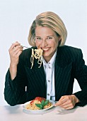Junge Frau isst Spaghetti mit Tomatensauce