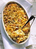 Noodle and ham bake with basil in casserole dish