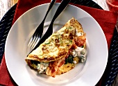 Onion omelette filled with spinach & bacon on plate