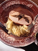 Smoked pork stuffed with plums and sauerkraut on a plate
