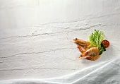Zwei Crevetten mit Salatdeko auf weißem Hintergrund