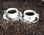 Two Cups of Coffee Surrounded By Coffee Beans