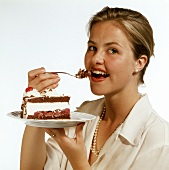 Model eating a piece of Black Forest cherry gateau