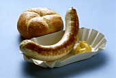 A sausage with mustard in paper tray, roll