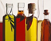 Verschiedene Öle in Flaschen, z.T. mit Kräutern