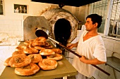 Israeli baker taking flat bread out of the oven