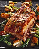 Roast pork neck joint with apricots and spring onions