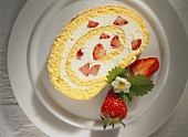 A piece of strawberry roulade on a cake plate