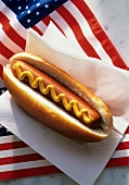 Hot dog in paper napkin on American flag