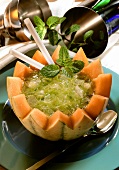Melon drink with mint and ice in half a honeydew melon