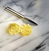 Dekoriermesser & zwei Zitronenhälften mit Zackenrand