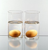 Two Glasses of Water; Each with a Brown Egg