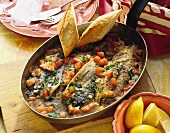 Mackerel with tomatoes in pan
