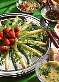 Asparagus platter with three kinds of sauce, garnished with strawberries