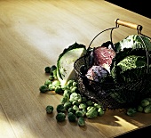 Rosenkohl, Wirsing, Weiß- & Rotkohl in Drathkorb auf Tisch