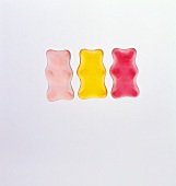 Three gummi bears (two pink and one gold)