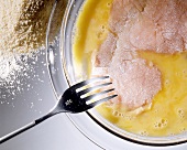 Breading an escalope: dipping the meat in egg