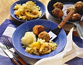 Meatballs with white cabbage and apple and mashed potato
