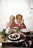 Zwei Mädchen beim Naschen von Süßspeisen mit Johannisbeeren