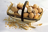 weiße & braune Eier auf Stroh im Spankorb, Deko: Getreide