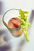 A glass of celery & tomato juice & stick of celery, from above