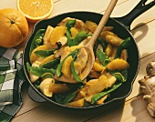 Turkey and orange ragout with mangetouts in pan