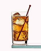 Ein Cuba Libre im Longdrinkglas mit rotem Cocktailspiess