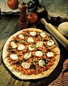 Pizza mit Tomaten, Mozzarella, Oliven & Basilikum