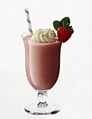 Strawberry milk shake in a glass with spoon & straw