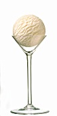 A scoop of vanilla ice cream in tall stemmed glass