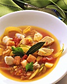 A plate of vegetable broth with diced turkey and croutons