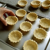 Placing home-made tartlets on the baking tray