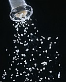 Salz fällt aus Salzmühle (schwarzer Hintergrund)