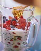 Berry shake: adding honey to milk & berries in measuring jug