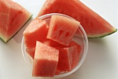 Pieces of water melon in plastic pot and slice of melon