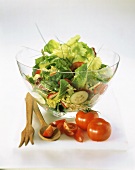 Gemischter Salat in Glasschüssel, Deko: Holzbesteck, Tomaten