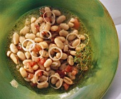 White bean salad with onion rings and tomatoes