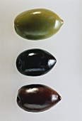 Eine grüne, eine schwarze & eine braune Olive