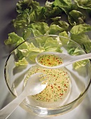 Herb & pepper vinaigrette in salad dish with salad servers